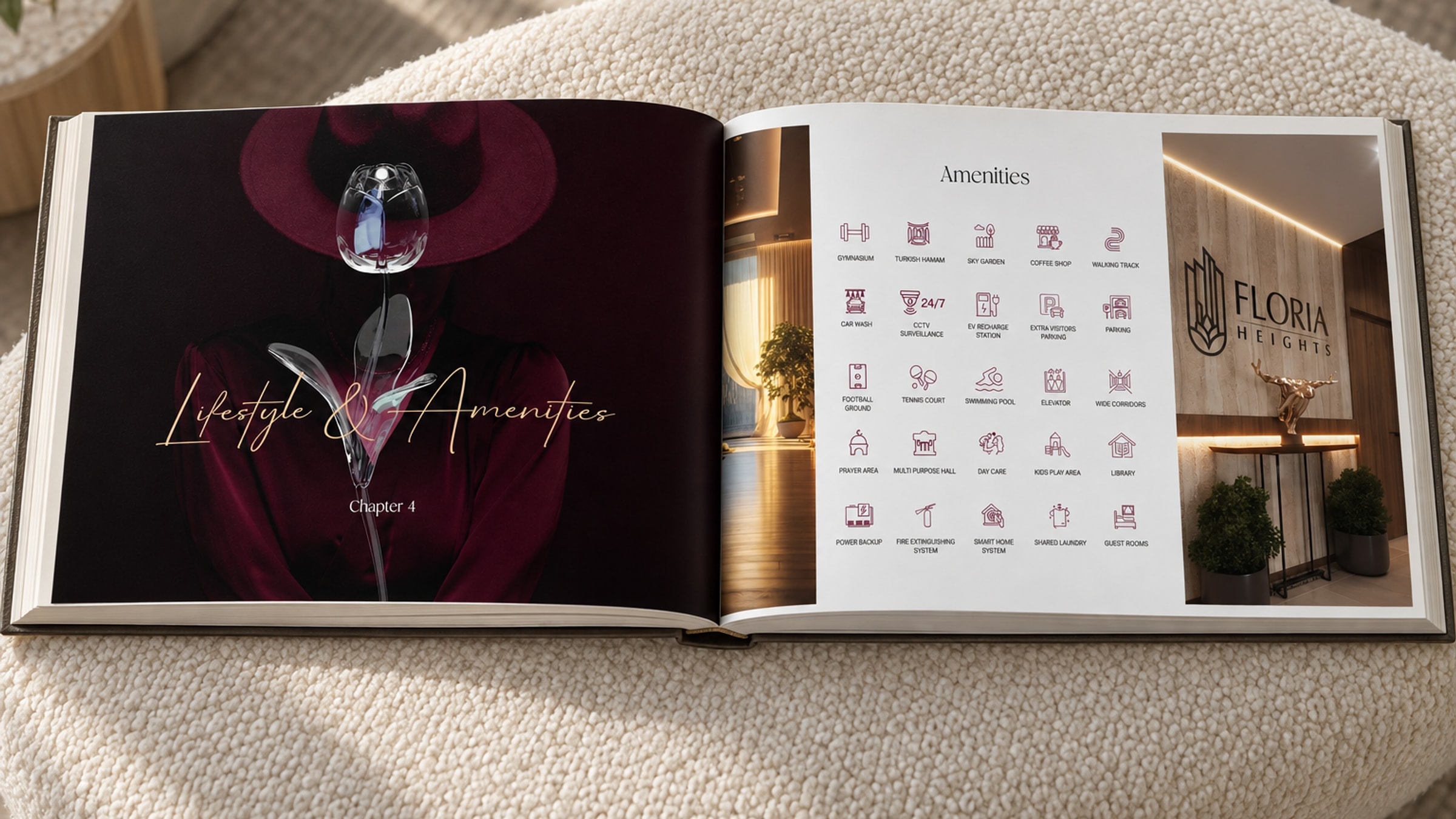 The book open on an ivory boucle ottoman: the Lifestyle and Amenities opener with a glass rose on the left page, the amenities grid and the mark on a wall on the right