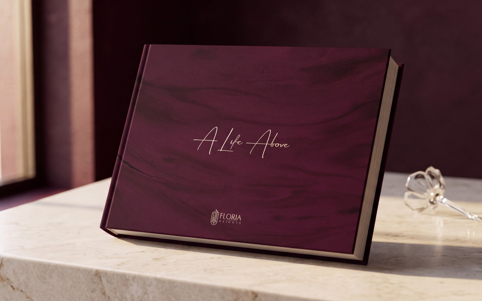 The Floria Heights sales book closed on cream marble, its wine cover carrying one line of champagne script